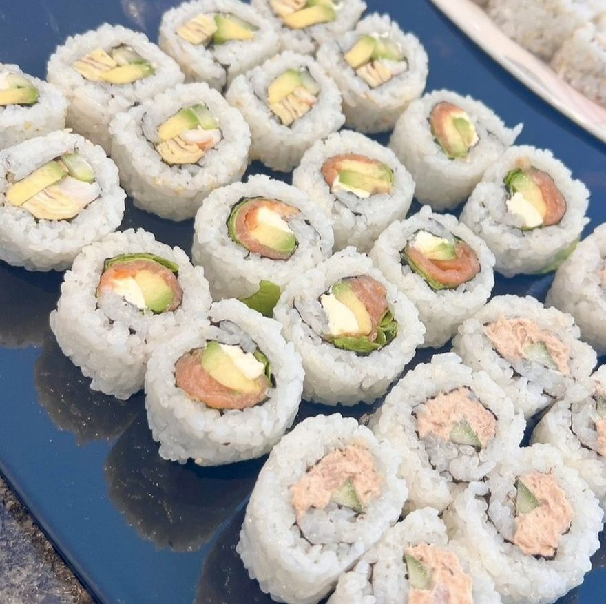 Frisch zubereitete Uramaki-Rollen auf dunkler Platte